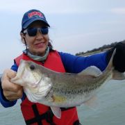 Happy woman with great black bass catch at lake el Cuchillo